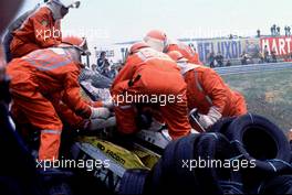 Marshals help Rene Arnoux (FRA) Renault Re 30B Turbo from his crashed car at Tarzan corner
