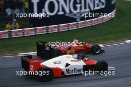 Michele Alboreto (ITA) Ferrari 156/85 passes Alain Prost (FRA) McLaren MP4/2B Tag Porsche