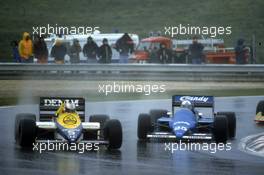 Nigel Mansell (GBR) Williams FW10 Honda battles with Andrea de Cesaris (ITA) Ligier JS25 Renault