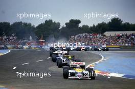 Nigel Mansell (GBR) Williams FW11 Honda 1st position leads a group