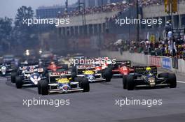 Ayrton Senna da Silva (BRA) Lotus 98T Turbo 1st position battles with Nigel Mansell (GBR) Williams FW11 Honda at start
