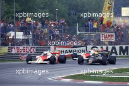 Ayrton Senna da Silva (BRA) Lotus 98T Renault  passes  Alain Prost (FRA) McLaren MP4/2C Tag Porsche 1st position at Curva Tosa