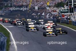 Nigel Mansell (GBR) Williams FW11 Honda 1st position battles with Ayrton Senna da Silva (BRA) Lotus 98T Renault at start