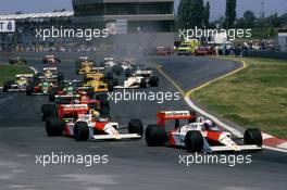 Alain Prost (FRA) McLaren MP4/4 Honda 2nd position leads Ayrton Senna da Silva (BRA) same car 1st position and the group at start