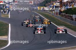 Alain Prost (FRA) McLaren MP4/4 Honda 1st position battles with team mate Ayrton Senna da Silva (BRA) at start