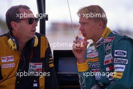 Mika Hakkinen (FIN) Lotus talks with Pat Symonds (GBR)
