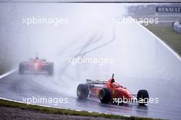 Eddie Irvine (IRL) Ferrari F310 Scuderia Ferrari leads team-mate Michael Schumacher (GER) 1st position