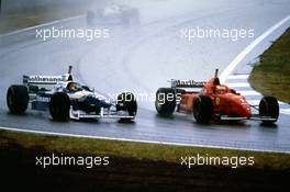 Michael Schumacher (GER) Ferrari F310 Scuderia Ferrari 1st position passes Jacques Villeneuve (CDN) Williams FW18 Renault Rothmans Williams Renault 3rd position