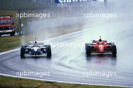 Michael Schumacher (GER) Ferrari F310 Scuderia Ferrari 1st position passes Jacques Villeneuve (CDN) Williams FW18 Renault Rothmans Williams Renault 3rd position