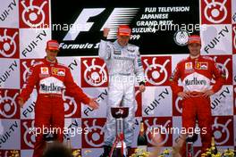 Michael Schumacher (GER) Ferrari 2nd position,Mika Hakkinen (FIN) McLaren Mercedes 1st position, Eddie Irvine (IRL) Ferrari 3rd position celebrates podium