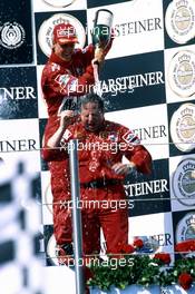 Michael Schumacher (GER) Ferrari 1st position celebrate on podium with Jean Todt (FRA)