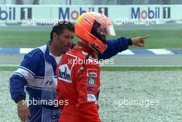 30.07.2000 Hockenheim, Deutschland, Ein Streckenposten zeigt Michael Schumacher den Weg in die Box nach seinem Startunfall heute beim Formel 1 Grand Prix von Deutschland in Hockenheim. c xpb.cc