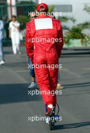 21.07.2002 Magny-Cours, Frankreich, F1 in Frankreich, Sonntag, Michael Schumacher fährt am Sonntag morgen vor dem WarmUp mit dem elektro Scooter im Paddock Bereich, Formel 1 Grand Prix (GP) von Frankreich 2002 (France, Nevers Magny - Cours) c xpb.cc - weitere Bilder auf der Datenbank unter www.xpb.cc - Email: info@xpb.cc