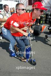 18.07.2002 Magny-Cours, Frankreich, F1 in Frankreich, Donnerstag, Michael Schumacher und Rubens Barrichello fahren gemeinsam mit dem Elektro-Scooter vom Motorhome zu der Box, im Paddock Bereich, Formel 1 Grand Prix (GP) von Frankreich 2002 (France, Nevers Magny - Cours) c xpb.cc - weitere Bilder auf der Datenbank unter www.xpb.cc - Email: info@xpb.cc