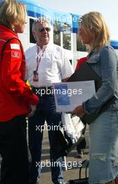 21.07.2002 Magny-Cours, Frankreich, F1 in Frankreich, Sonntag, Corinna Schumacher (Frau von F1 Fahrer Michael Schumacher) kommt am Sonntag morgen vor dem WarmUp im Paddock Bereich an und geht in das Ferrari Motorhome, mit dabei Schumacher Manager Willi Weber und Pressesprecherin Sabine Kehm - Corinna hat ein Umschlag in der Hand auf dem "WELTWEIT ERSTER" steht, Formel 1 Grand Prix (GP) von Frankreich 2002 (France, Nevers Magny - Cours) c xpb.cc - weitere Bilder auf der Datenbank unter www.xpb.cc - Email: info@xpb.cc