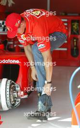 15.08.2002 Budapest, Ungarn, F1 in Budapest, Donnerstag, Michael Schumacher (Ferrari) in der Box - nimmt Platz in seinem Wagen und testet den Sitz - hier zieht er seine blau/schwarzen Cowboystifel aus, Formel 1 Grand Prix (GP) von Ungarn 2002 (Hungary, Budapest) c xpb.cc - weitere Bilder auf der Datenbank unter www.xpb.cc - Email: info@xpb.cc