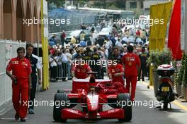 22.05.2002 Monte Carlo, Monaco, F1 in Monaco, Mittwoch, Vorbereitungen in Monte Carlo, hier im Hafen, das Ferrari Team schiebt den F1 Wagen durch den regulären Verkehr zur technischen Abnahme - und wird von Schaulustigen beobachtet, Formel 1 Grand Prix (GP) von Monaco 2002 in Monte Carlo, Monaco c xpb.cc Email: info@xpb.cc, weitere Bilder auf der Datenbank: www.xpb.cc
