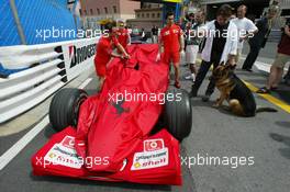 22.05.2002 Monte Carlo, Monaco, F1 in Monaco, Mittwoch, Vorbereitungen in Monte Carlo, hier im Hafen, das Ferrari Team schiebt den F1 Wagen durch den regulären Verkehr zur technischen Abnahme - und wird von Schaulustigen hier mit Hund beobachtet, Formel 1 Grand Prix (GP) von Monaco 2002 in Monte Carlo, Monaco c xpb.cc Email: info@xpb.cc, weitere Bilder auf der Datenbank: www.xpb.cc