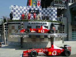 29.09.2002 Indianapolis, USA, F1 in Indianapolis, Sonntag 29.09.2002, Podium, P. Martinelli, Michael Schumacher, Rubens Barrichello, David Coulthard, der Siegerwagen wurde auf einer Bühne "hochgehoben", 2002 SAP United States Grand Prix - (USGP, Formel 1, USA, Grand Prix, GP). c xpb.cc - weitere Bilder auf der Datenbank unter www.xpb.cc - Email: info@xpb.cc