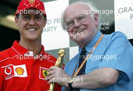 27.09.2002 Indianapolis, USA, F1 in Indianapolis, Freitag, Professor Sid Watkins überreicht den "Bernie Award" 2002 (Charity, Brain & Spine Foundation) an Michael Schumacher (Fahrer des Jahres) im Paddock Bereich, 2002 SAP United States Grand Prix - (USGP, Formel 1, USA, Grand Prix, GP). c xpb.cc - weitere Bilder auf der Datenbank unter www.xpb.cc - Email: info@xpb.cc