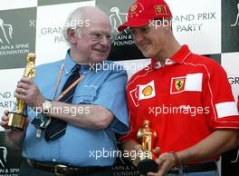 27.09.2002 Indianapolis, USA, F1 in Indianapolis, Freitag, Professor Sid Watkins überreicht den "Bernie Award" 2002 (Charity, Brain & Spine Foundation) an Michael Schumacher (Fahrer des Jahres) im Paddock Bereich, 2002 SAP United States Grand Prix - (USGP, Formel 1, USA, Grand Prix, GP). c xpb.cc - weitere Bilder auf der Datenbank unter www.xpb.cc - Email: info@xpb.cc