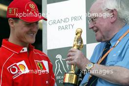 27.09.2002 Indianapolis, USA, F1 in Indianapolis, Freitag, Professor Sid Watkins überreicht den "Bernie Award" 2002 (Charity, Brain & Spine Foundation) an Michael Schumacher (Fahrer des Jahres) im Paddock Bereich, 2002 SAP United States Grand Prix - (USGP, Formel 1, USA, Grand Prix, GP). c xpb.cc - weitere Bilder auf der Datenbank unter www.xpb.cc - Email: info@xpb.cc