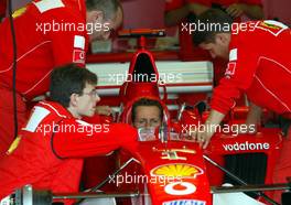 27.09.2002 Indianapolis, USA, F1 in Indianapolis, Freitag, vor dem Training nimmt Michael Schumacher (Ferrari) in seinem Wagen platz und lässt sich den Sitz anpassen, 2002 SAP United States Grand Prix - (USGP, Formel 1, USA, Grand Prix, GP). c xpb.cc - weitere Bilder auf der Datenbank unter www.xpb.cc - Email: info@xpb.cc