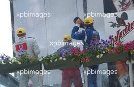 08.06.2003 Klettwitz, Deutschland, Podium, Bernd Schneider (GER), Vodafone AMG-Mercedes, Peter Dumbreck (GBR), OPC Team Phoenix, and Mattias Ekström (SWE), PlayStation 2 Red Bull Abt-Audi, spraying champaign on to the bobbo's behind the podium - DTM 2003 in Klettwitz, EuroSpeedway Lausitz, Lausitzring (Deutsche Tourenwagen Masters)  - Weitere Bilder auf www.xpb.cc, eMail: info@xpb.cc - Belegexemplare senden. c Copyright: Kennzeichnung mit: Miltenburg / xpb.cc