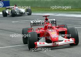 20.04.2003 Imola, San Marino, SM, Formel1, Sonntag (Ostern), Rennen, Michael Schumacher (D, 01), Scuderia Ferrari Marlboro, F2002, auf der Strecke (Track) fährt über die Ziellinie und jubelt mit der Faust, hinten Jenson Button (GB, BAR Honda) - (Imola, Autodromo Enzo e Dino Ferrari, 4,933 km - Grand Prix of San Marino 2003, Formel 1, F1)  - Weitere Bilder auf www.xpb.cc, eMail: info@xpb.cc - Belegexemplare senden. Abdruck ist honorarpflichtig. c Copyrightnachweis: xpb.cc