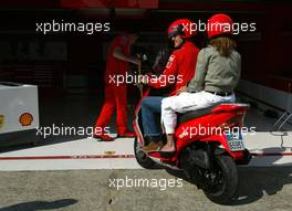 17.04.2003 Imola, San Marino, SM, Formel1, Donnerstag, Michael Schumacher (D, Ferrari) und seine Frau Corinna auf dem Roller / Scooter - fahren auf der Strecke um den Fotografen zu engehen fährt MS durch die Ferrari Box in den Paddock zurück - (Imola, Autodromo Enzo e Dino Ferrari, 4,933 km - Grand Prix of San Marino 2003, Formel 1, F1)  - Weitere Bilder auf www.xpb.cc, eMail: info@xpb.cc - Belegexemplare senden. Abdruck ist honorarpflichtig. c Copyrightnachweis: xpb.cc