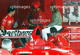 17.04.2003 Imola, San Marino, SM, Formel1, Donnerstag, Michael Schumacher (D, Ferrari) und seine Frau Corinna auf dem Roller / Scooter - fahren auf der Strecke um den Fotografen zu engehen fährt MS durch die Ferrari Box in den Paddock zurück - (Imola, Autodromo Enzo e Dino Ferrari, 4,933 km - Grand Prix of San Marino 2003, Formel 1, F1)  - Weitere Bilder auf www.xpb.cc, eMail: info@xpb.cc - Belegexemplare senden. Abdruck ist honorarpflichtig. c Copyrightnachweis: xpb.cc