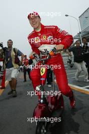 12.10.2003 Suzuka, Japan, F1 in Japan, Sonntag, FIA F1 Weltmeister Michael Schumacher (D, Ferrari) fährt mit dem Scooter zum Team - Formel 1 Grand Prix (GP) von Japan 2003 (Suzuka Race Circuit, Fans) - Weitere Bilder auf www.xpb.cc, eMail: info@xpb.cc - Belegexemplare senden. Abdruck ist honorarpflichtig. c Copyrightnachweis: xpb.cc