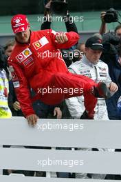 26.09.2003 Indianapolis, USA, F1 in Indy (USA), Freitag, Michael Schumacher (D, Ferrari) springt über die Leitplanke, nach dem Qualyfying, Gruppenbild mit Juan-Pablo Montoya (CO, BMW WilliamsF1), Bernie Ecclestone, Michael Schumacher (D, Ferrari), Kimi Raikkonen, (FIN, McLaren Mercedes) - 2003 United States Grand Prix (Indianapolis Motor Speedway, USGP, Formel 1, Brickyard) - Weitere Bilder auf www.xpb.cc, eMail: info@xpb.cc - Belegexemplare senden. Abdruck ist honorarpflichtig. c Copyrightnachweis: xpb.cc