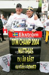 19.09.2004 Brno, Czech Republic,  DTM, Sunday, Dr. Wolfgang Ullrich (GER), Audi's Head of Sport, with the best friend of Mattias Ekström, with the 2004 DTM champion pitboard - DTM Season 2004 at Automotodrom Brno, Czech Republic (Deutsche Tourenwagen Masters)