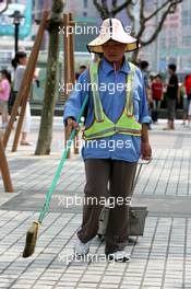 15.07.2004 Shanghai, China,  DTM, Thursday, A local worksman cleaning the pavement - DTM Season 2004 at Pu Dong Street Circuit Shanghai (Deutsche Tourenwagen Masters)