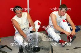 18.07.2004 Shanghai, China,  DTM, Sunday, Christian Abt (GER), Audi Sport Team Abt Sportsline, Portrait (left) and Martin Tomczyk (GER), Audi Sport Team Abt, Portrait (right), talking a break after the warm-up with some refreshing aire from a fan - DTM Season 2004 at Pu Dong Street Circuit Shanghai (Deutsche Tourenwagen Masters)