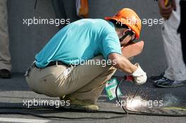 18.07.2004 Shanghai, China,  DTM, Sunday, Local worksman are welding the manhole covers after the accident of Bernd Mayländer (GER), CLK AMG-Mercedes, Mercedes CLK-DTM at the first start. All covers on the entire circuit were welded which caused a delay of about 4 hours - DTM Season 2004 at Pu Dong Street Circuit Shanghai (Deutsche Tourenwagen Masters)