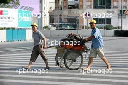 18.07.2004 Shanghai, China,  DTM, Sunday, Local worksman walking the entire circuit to weld all manhole covers after the accident of Bernd Mayländer (GER), CLK AMG-Mercedes, Mercedes CLK-DTM at the first start. All covers on the entire circuit were welded which caused a delay of about 4 hours - DTM Season 2004 at Pu Dong Street Circuit Shanghai (Deutsche Tourenwagen Masters)