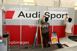 15.07.2004 Shanghai, China,  DTM, Thursday, Local worksman putting on the Audi Sport stickers in the Audi pitbox - DTM Season 2004 at Pu Dong Street Circuit Shanghai (Deutsche Tourenwagen Masters)