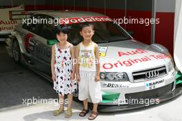 15.07.2004 Shanghai, China,  DTM, Thursday, Two Chinese children posing for a Audi A4 DTM car - DTM Season 2004 at Pu Dong Street Circuit Shanghai (Deutsche Tourenwagen Masters)