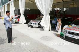 15.07.2004 Shanghai, China,  DTM, Thursday, A father photographing his two children in front of a DTM car - DTM Season 2004 at Pu Dong Street Circuit Shanghai (Deutsche Tourenwagen Masters)