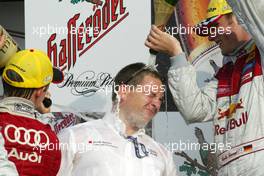 05.09.2004 Zandvoort, The Netherlands,  DTM, Sunday, One of the Abt team manager gets a champaign shower on the podium from Mattias Ekström (SWE), Audi Sport Team Abt (1st, left) and Martin Tomczyk (GER), Audi Sport Team Abt (2nd, right) - DTM Season 2004 at Circuit Park Zandvoort (Deutsche Tourenwagen Masters)