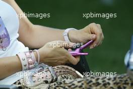 04.03.2004 Melbourne, Australia, F1, Thursday, March, Cora Schumacher, GER, Wife of Ralf Schumacher, plays with her phone. Formula 1 World Championship, Rd 1, Australian Grand Prix. www.xpb.cc, EMail: info@xpb.cc - copy of publication required for printed pictures. Every used picture is fee-liable. c Copyright: xpb.cc