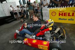 04.03.2004 Melbourne, Australia, F1, Thursday, March, Shell Press Conference with Michael Schumacher, GER, Ferrari drives around a child in a two seater go kart in the "Shell House", Formula 1 World Championship, Rd 1, Australian Grand Prix. www.xpb.cc, EMail: info@xpb.cc - copy of publication required for printed pictures. Every used picture is fee-liable. c Copyright: xpb.cc