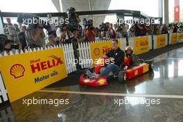 04.03.2004 Melbourne, Australia, F1, Thursday, March, Shell Press Conference with Michael Schumacher, GER, Ferrari takes a child around a short circuit in a two seater go kar in the "Shell House", Formula 1 World Championship, Rd 1, Australian Grand Prix. www.xpb.cc, EMail: info@xpb.cc - copy of publication required for printed pictures. Every used picture is fee-liable. c Copyright: xpb.cc