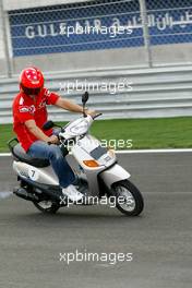 01.04.2004 Manama, Bahrain, F1, Thursday, April, Michael Schumacher, GER, Scuderia Ferrari Marlboro, F2004, rides a moped around the new Bahrain circuit for the first time, Formula 1 World Championship, Rd 3, Bahrain Grand Prix, BHR