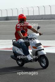 01.04.2004 Manama, Bahrain, F1, Thursday, April, Michael Schumacher, GER, Scuderia Ferrari Marlboro, F2004,  rides around the new Bahrain track on a moped, Formula 1 World Championship, Rd 3, Bahrain Grand Prix, BHR