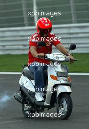 01.04.2004 Manama, Bahrain, F1, Thursday, April, Michael Schumacher, GER, Scuderia Ferrari Marlboro, F2004, rides a moped around the new Bahrain circuit for the first time, Formula 1 World Championship, Rd 3, Bahrain Grand Prix, BHR