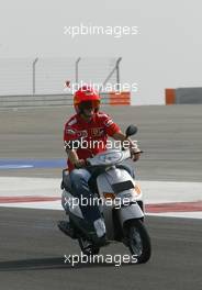 01.04.2004 Manama, Bahrain, F1, Thursday, April, Michael Schumacher, GER, Scuderia Ferrari Marlboro, F2004, rides a moped around the new Bahrain circuit for the first time, Formula 1 World Championship, Rd 3, Bahrain Grand Prix, BHR