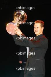 10.12.2004 Monte Carlo, Monaco Michael Schumacher, GER, Ferrari with the World Championship trophy - Friday, December, 2004 FIA Awards Gala